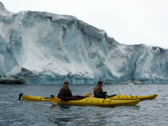 Remando ao lado das peredes monumentais de gelo de uma geleira em Brown Bluff, na Antártida